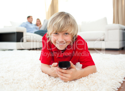 Smiling boy watching TV lying on the floor