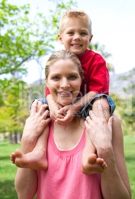 Cheerful mother giving her son piggy-back ride