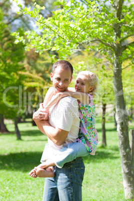 Lively father giving his daughter piggy-back ride