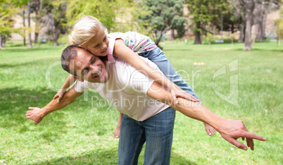 Cheerful little girl having fun with her father