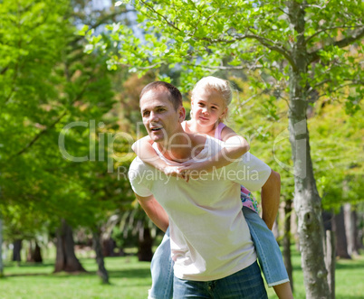 Attentive father giving his daughter piggy-back ride