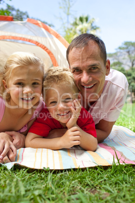 Happy father and his children lying on the grass