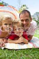 Happy father and his children lying on the grass