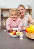 Caring mother eating fruit with her daughter