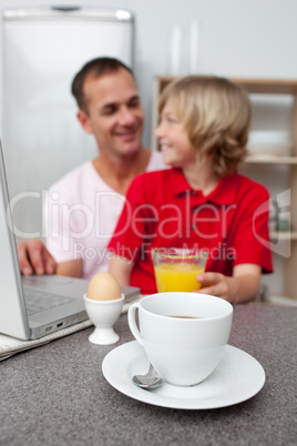 Jolly father and his son having breakfast