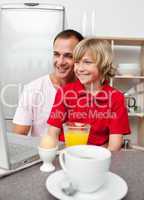 Cheerful father and his son having breakfast