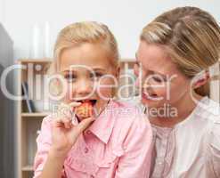 Lively little girl eating fruit with her mother