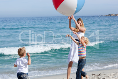 Happy mother and her children playing with a ball