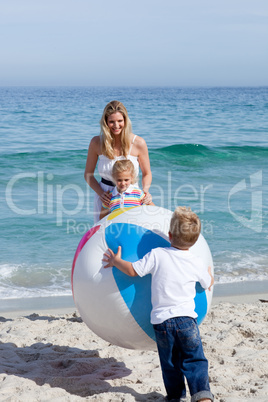 Caring mother and her children playing with a ball