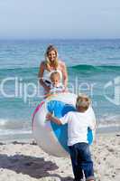 Caring mother and her children playing with a ball