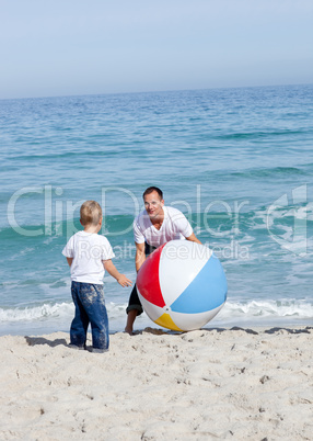 Joyful father and his son playing with a ball