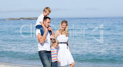 Lively family walking on the sand