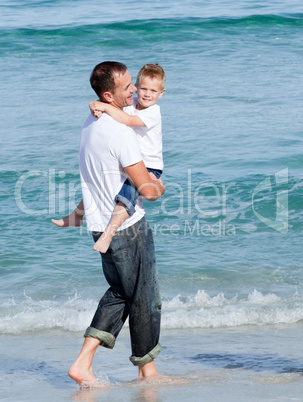 Cute little boy and his father walking on the sand