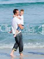 Cute little boy and his father walking on the sand