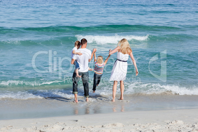 Jolly family walking on the sand