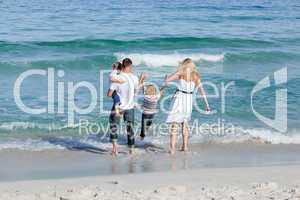 Jolly family walking on the sand