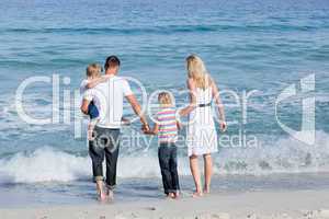 Happy family walking on the sand