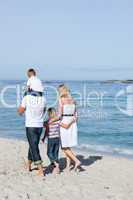 Cheerful family walking on the sand