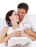 Couple drinking coffee and reading newspaper