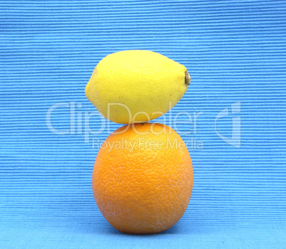 Zitrone auf Orange gestapelt auf blauem Hintergrund