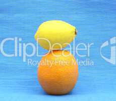 Zitrone auf Orange gestapelt auf blauem Hintergrund