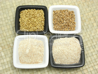 Porzellanschalen mit Getreide und Mehl auf grauer Matte