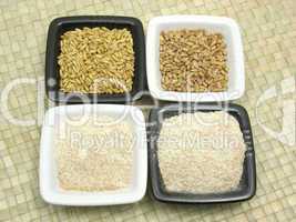 Porzellanschalen mit Getreide und Mehl auf grauer Matte