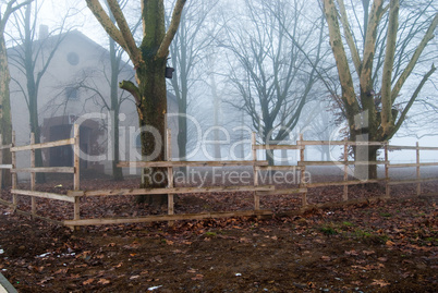 Foggy house behind the wooden fence