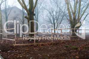 Foggy house behind the wooden fence