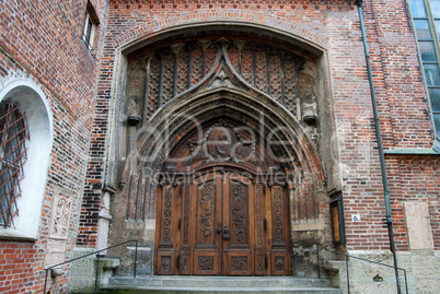 Ornate wooden dor th the church in Munich, Bavaria, Germany