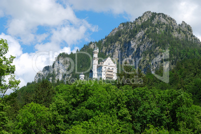 Castle Neuschwanstein in mountain forest, Alps
