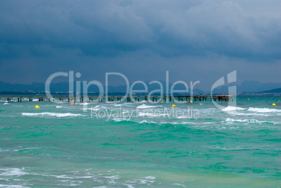 Turquoise water and the wooden pier in stormy weather, Majorca island, Spain