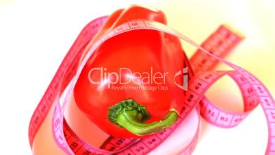 Tape measure wrapped around rotating red pepper, loopable
