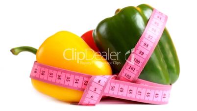 Tape measure wrapped around rotating three peppers, loopable