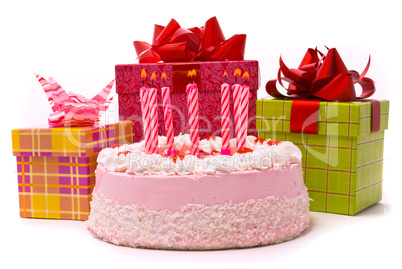 Pink pie with eight candles and gifts in boxes on a white backgr