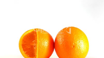 Close up of rotating two oranges isolated on a white background, loopable