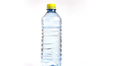 Close up of rotating bottle of water isolated on a white background, loopable