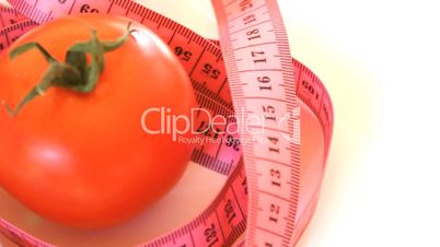 Tape measure wrapped around rotating tomato, loopable