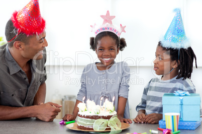 Smiling little girl and her family celebrating her birthday