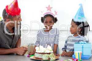 Smiling little girl and her family celebrating her birthday