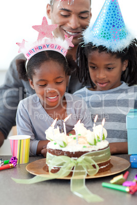 Ethnic little girl and her family celebrating her birthday