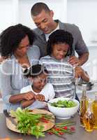 Affectionate family preparing salad together