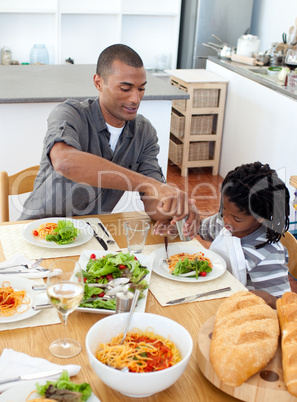 Ethnic little boy dining with his father