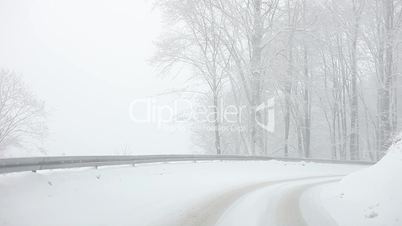 Car driving on Snow Blizzard on winter forest road