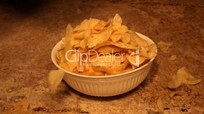 Potato chips dropping into bowl reverse