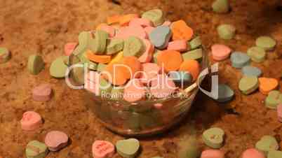 Valentine candy hearts slow drop into bowl