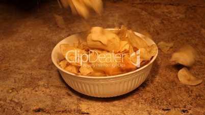Potato chips dropping into bowl