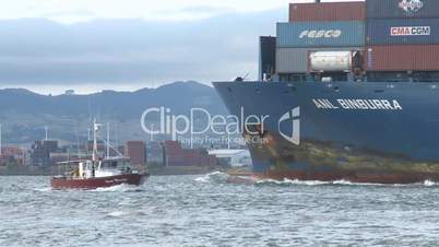 container ship and fishing boat pass