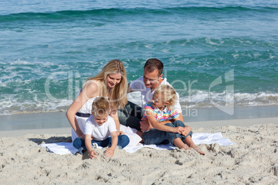 Happy family playing on the sand