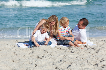 Attentive parents with their children sitting on the sand